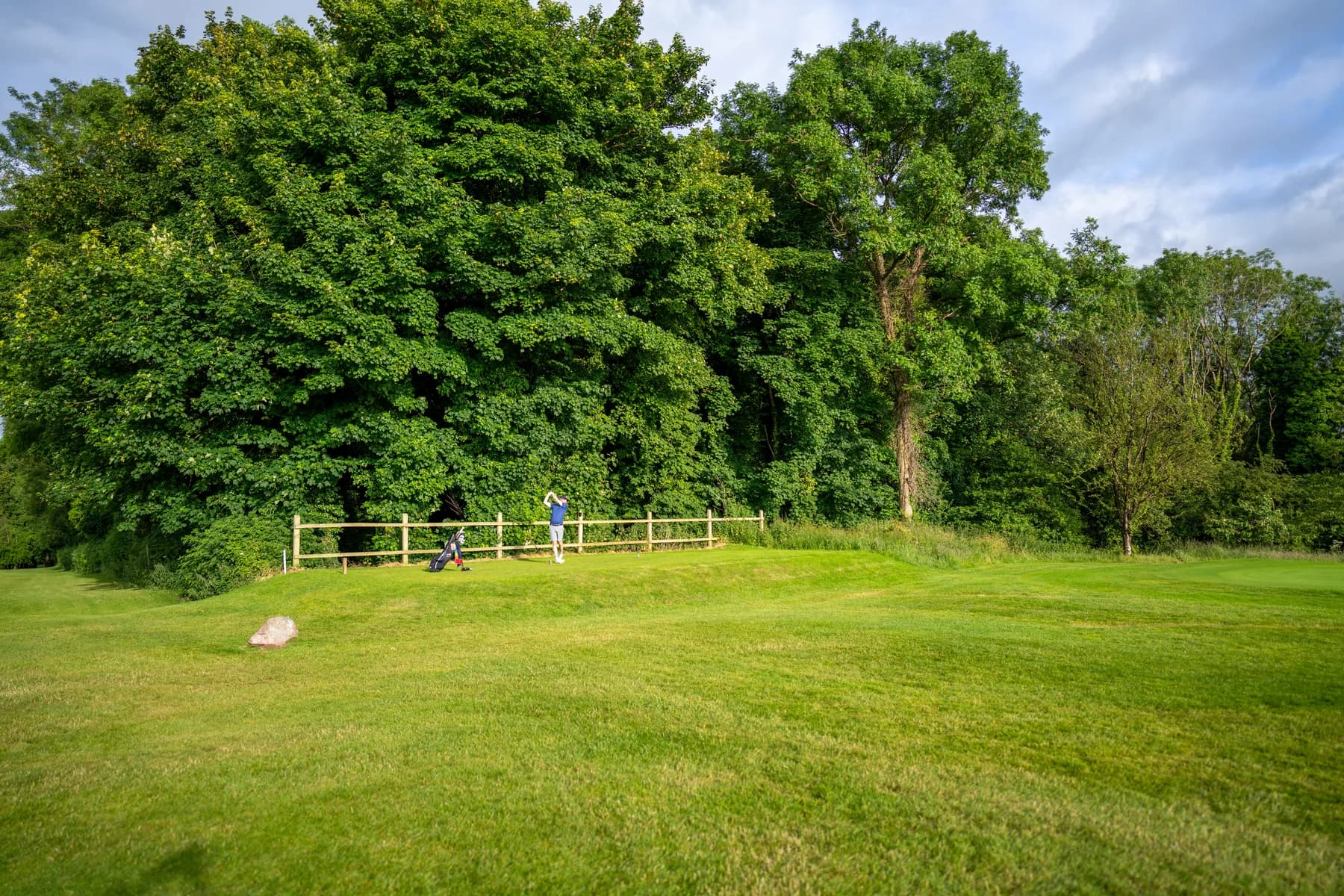 A golfer and trolley beside mature woodland at Long Ashton Golf Club in original project photography.