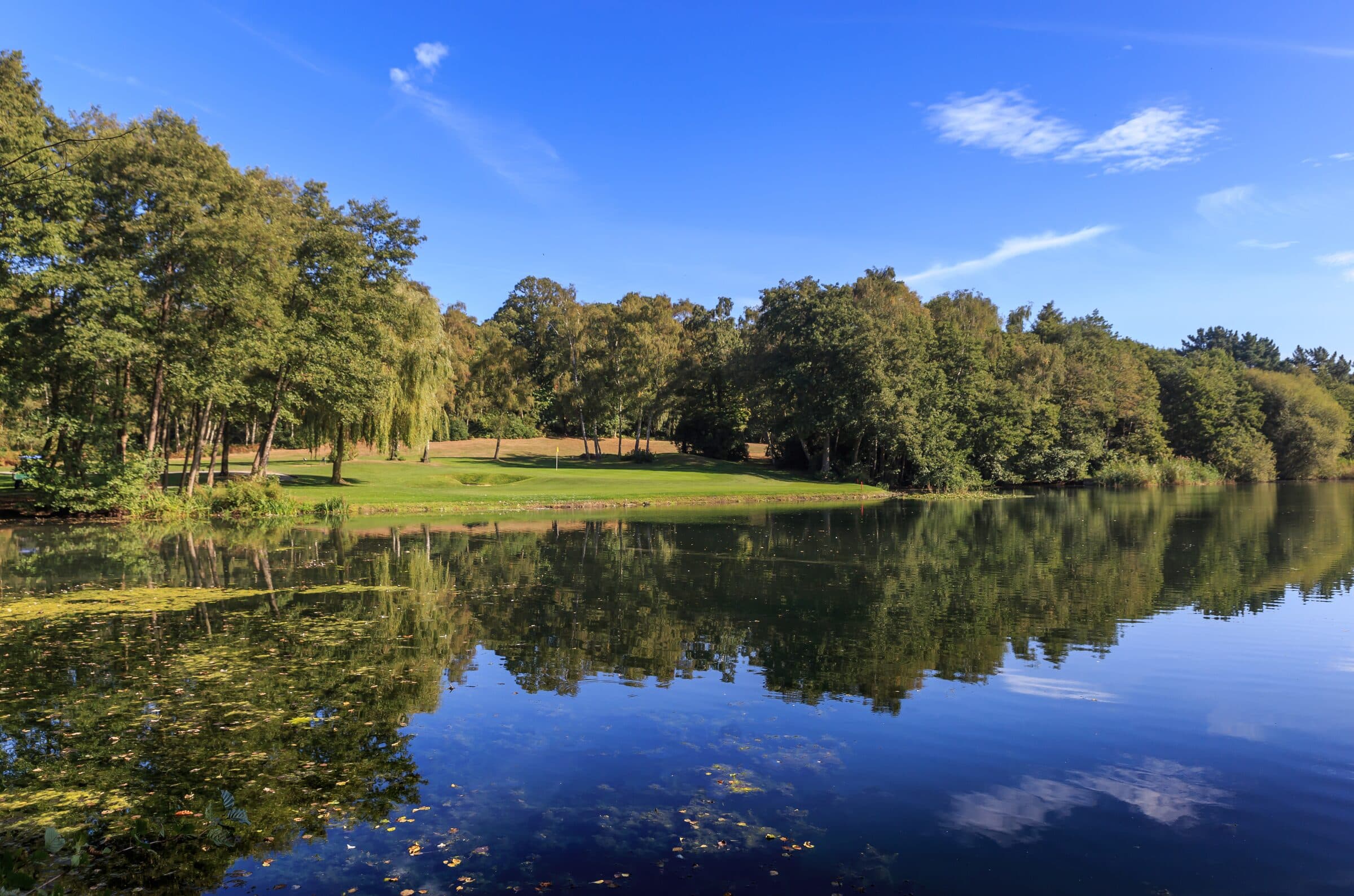 Silvermere's 17th hole, with the green and footbridge reflected in the lake.