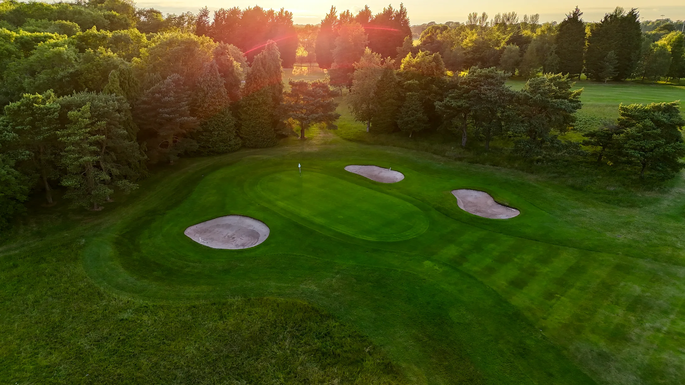 A sunset aerial view across a green and bunkers at Long Ashton Golf Club from the original project photography.