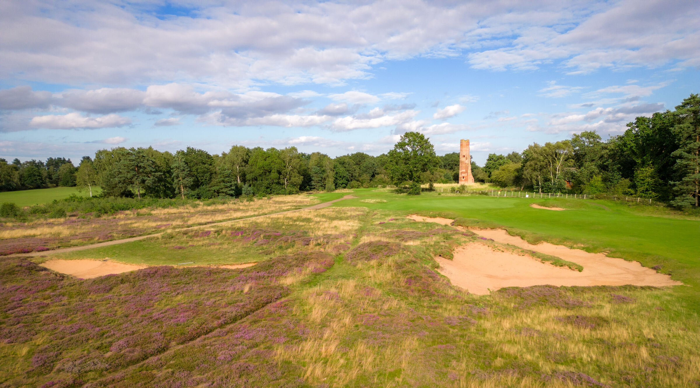 The Hotchkin Course tower beyond heather and bunkers at Woodhall Spa.